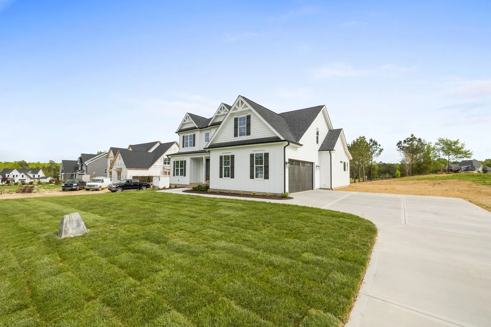Contemporary suburban house with a large maintained lawn and mature trees surrounding the property
